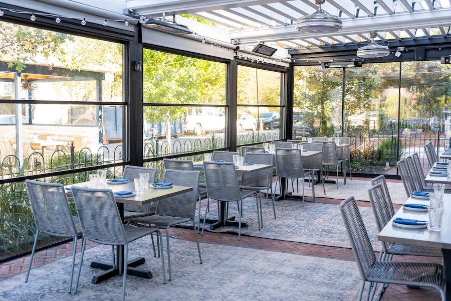 covered outdoor patio with metal dining sets and string lights